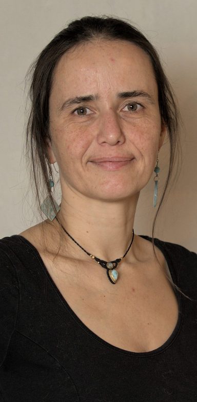 Linda Dieye Frau mit langen, dunklen Haaren, schmalem Gesicht und einem schlichten, schwarzen Oberteil.