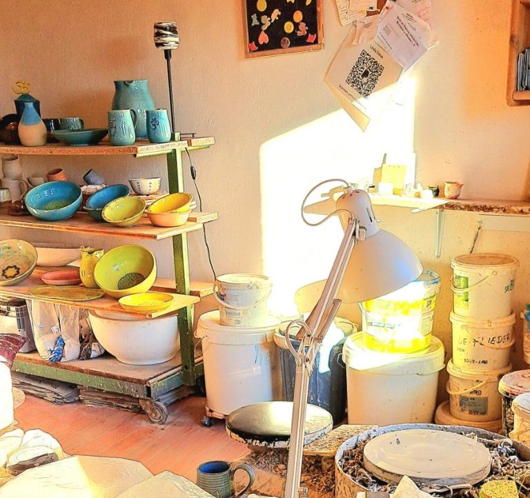 Töpferei mieten Helle Töpferei mit bunten Töpfen, Regalen und Werkstattutensilien.